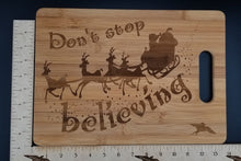 Load image into Gallery viewer, Don&#39;t stop believing santa bamboo cutting board
