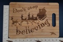 Load image into Gallery viewer, Don&#39;t stop believing santa bamboo cutting board - Altered Goods
